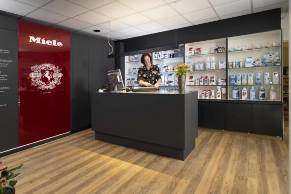 De medewerkster van Miele Center Bingé, Tania, staat aan de toonbank en pakt een product in als cadeau